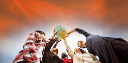 Image of people holding up a globe 