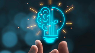 Hand holding a brain/light bulb illustration